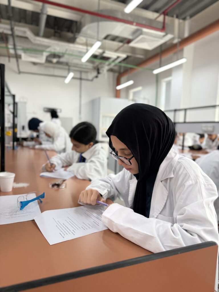 Student in a lab writing on paper exam